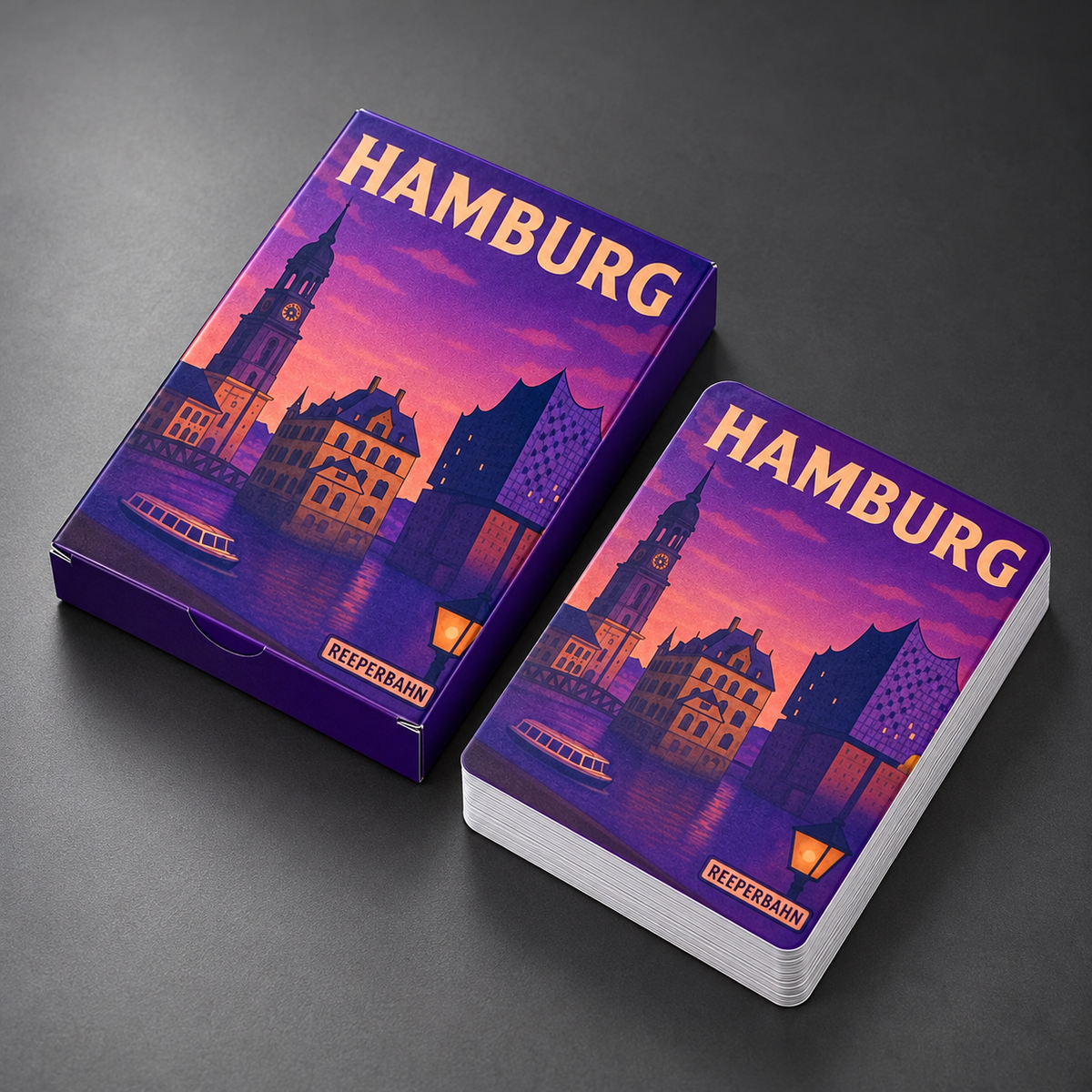 Hamburg-Spielkarten und Verpackung in Dreiviertelansicht auf graphitgrauem Hintergrund